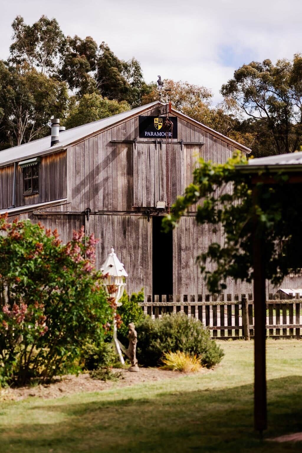 A rustic barn with a sign reading 'PARAMORCI'.