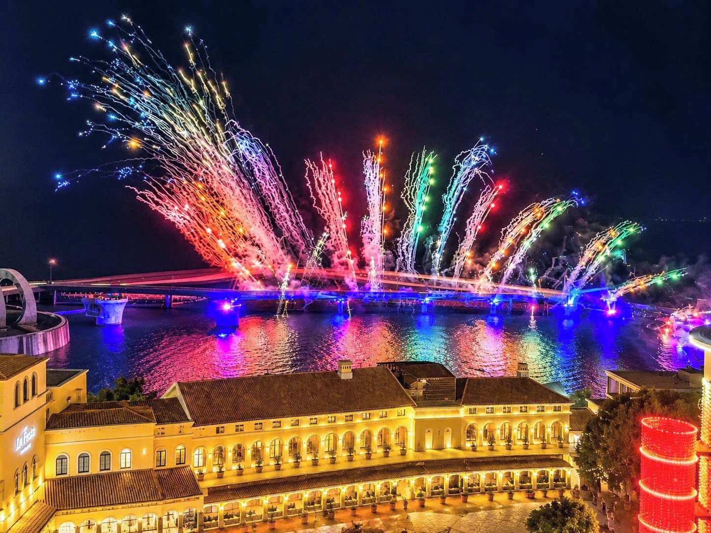 Edificio histórico con patio, puente y exhibición de fuegos artificiales.
