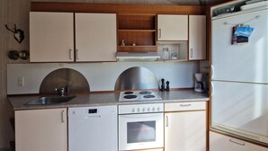 A compact kitchen with a dishwasher, stove, oven, and refrigerator. - Nice home in ålbæk with sauna (Ålbæk)