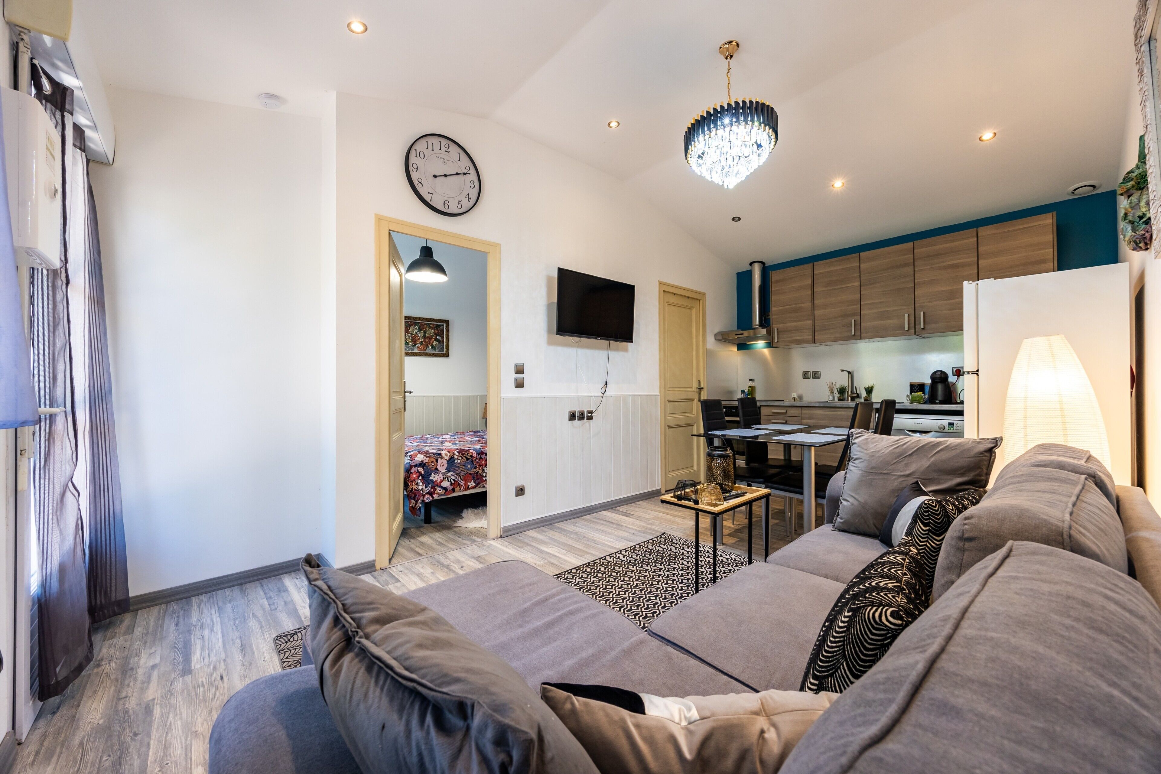 En moderne stue med sofa, spiseplads og køkken.