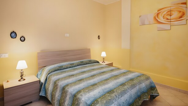 A bedroom with a bed, nightstands, and wall art. - Studio Apartment 'Bellavista' with Sea View, Shared Pool and Wi-Fi (Poggi)