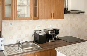 A kitchen with wooden cabinets, a stainless steel sink, a coffee maker, and a toaster. - Nice home in Donji Kraljevec with WiFi (Donji Kraljevec)