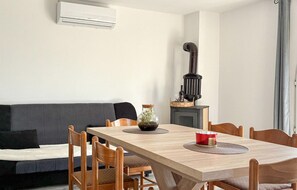 A dining area with a wooden table, chairs, a black stove, and a grey sofa. - Nice home in Donji Kraljevec with WiFi (Donji Kraljevec)