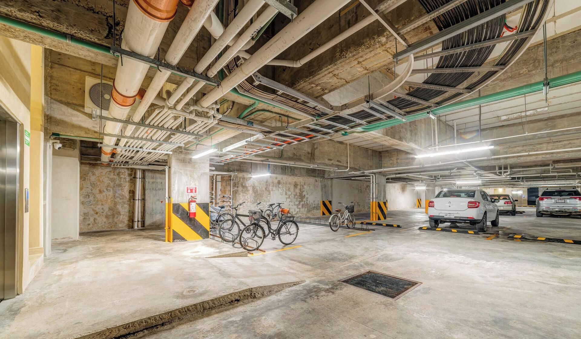 Eine Tiefgarage mit Betonwänden, mehreren Ebenen und einem Feuerlöscher.