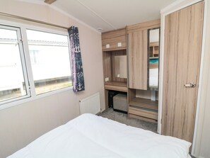 A bedroom with a bed, a window, a radiator, and a wardrobe. - 42 Oak Green (Filey)