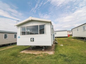 A mobile home with a small porch, a window, and a door. - 42 Oak Green (Filey)