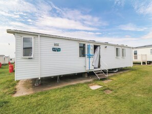A mobile home with a door open, a window, and a small step leading to the entrance. - 42 Oak Green (Filey)