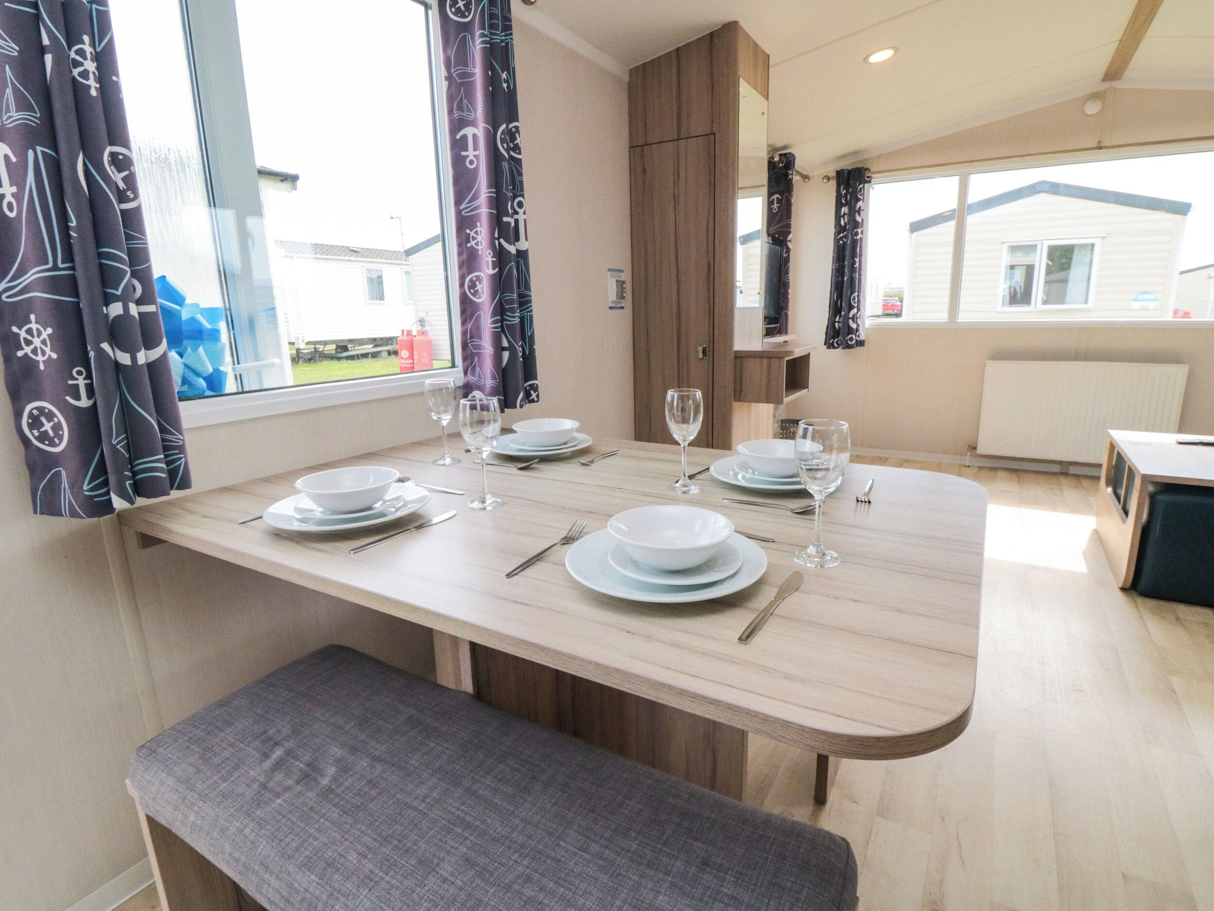 A dining area with a table set for four, including plates, glasses, and cutlery.