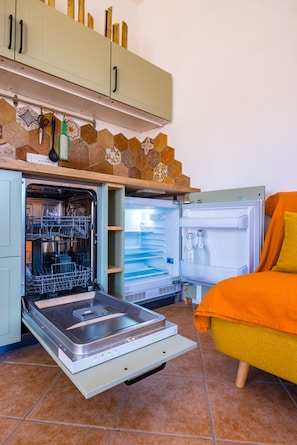 Eine kompakte Küche mit Geschirrspüler, Backofen und Kühlschrank.