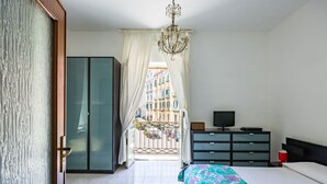 A bedroom with a bed, a TV, a dresser, and a wardrobe. - Pizzarchouse (Naples)