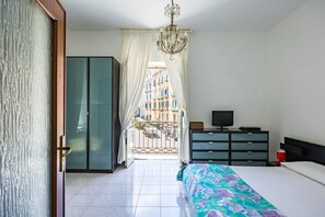 Ein Schlafzimmer mit einem Bett, einem Fernseher, einem Schminktisch und einem Kleiderschrank.