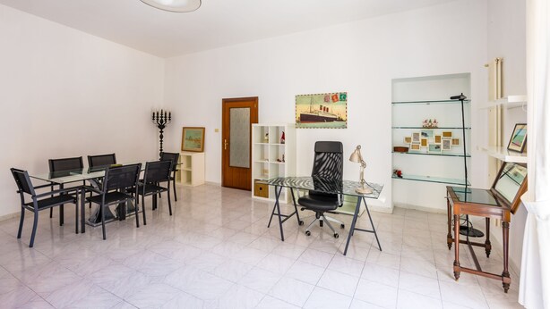 A spacious room with a dining table, chairs, a glass desk, a computer, and a bookshelf. - Pizzarchouse (Naples)