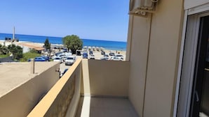 Un balcon avec vue sur un parking et la mer.