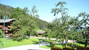 A residential area with a paved driveway, wooden houses, and a playground. - Apartment “Gästehaus Christoph” with Mountain View, Balcony and Wi-Fi (Ried im Zillertal)