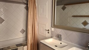A bathroom with a double sink, a shower curtain, and a mirror with a decorative frame. - Spacious Apartment: 20 Minutes from Disneyland / 30 Minutes from Paris (Thorigny-sur-Marne)