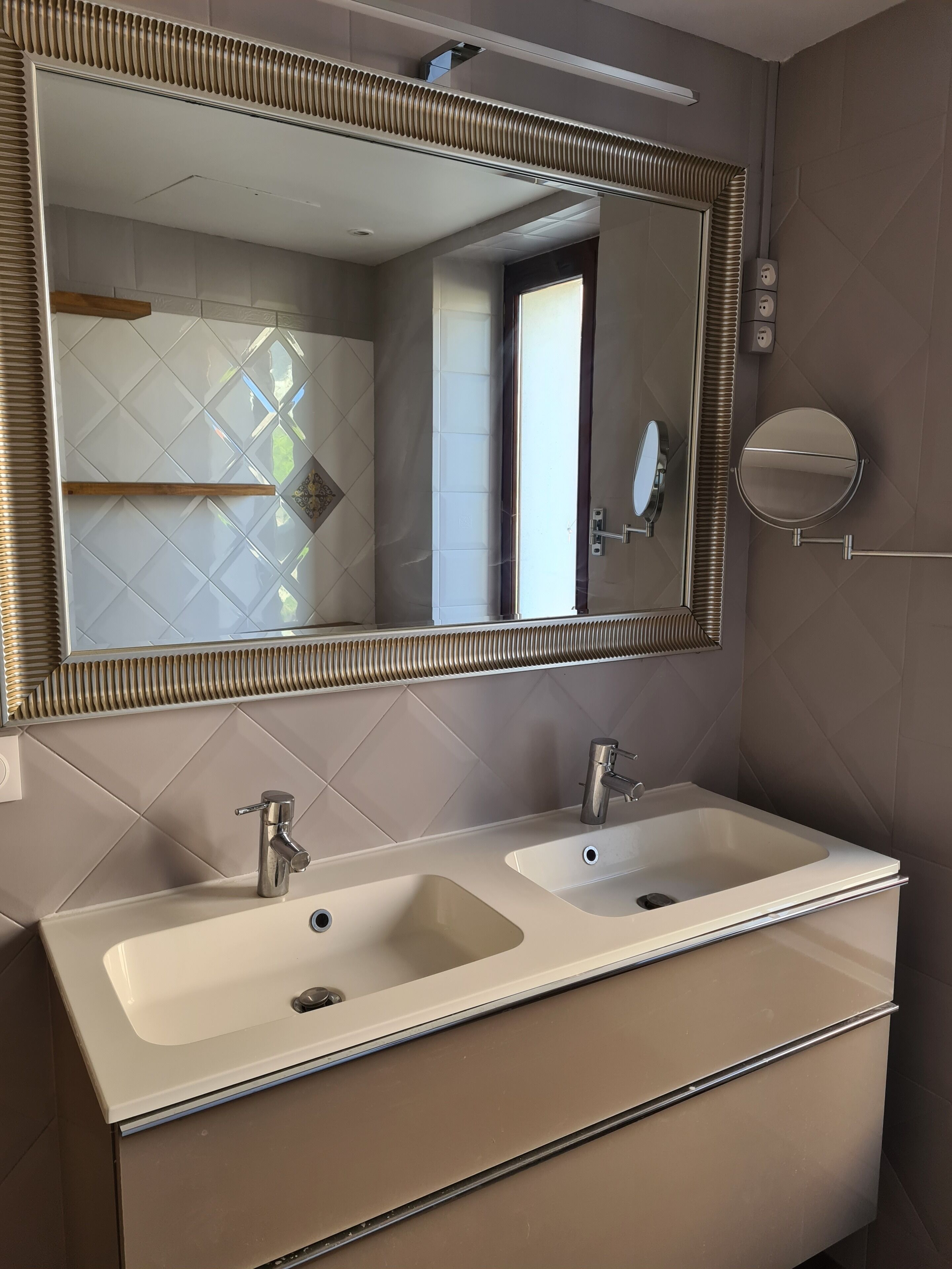 A bathroom with two sinks, a mirror, and a towel rack.