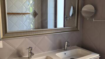 A bathroom with two sinks, a mirror, and a towel rack.