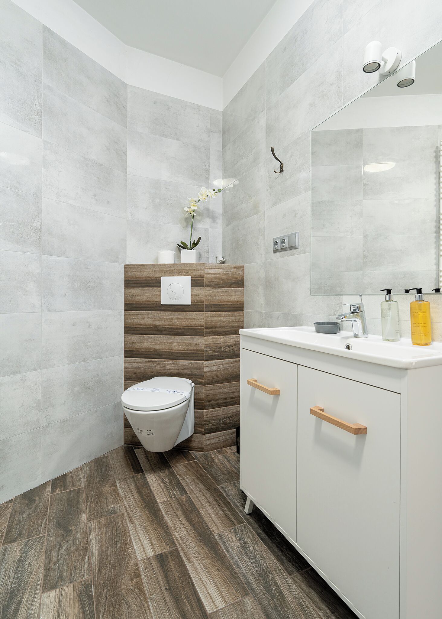 Ein modernes Badezimmer mit Toilette, Waschtisch und Spiegel.