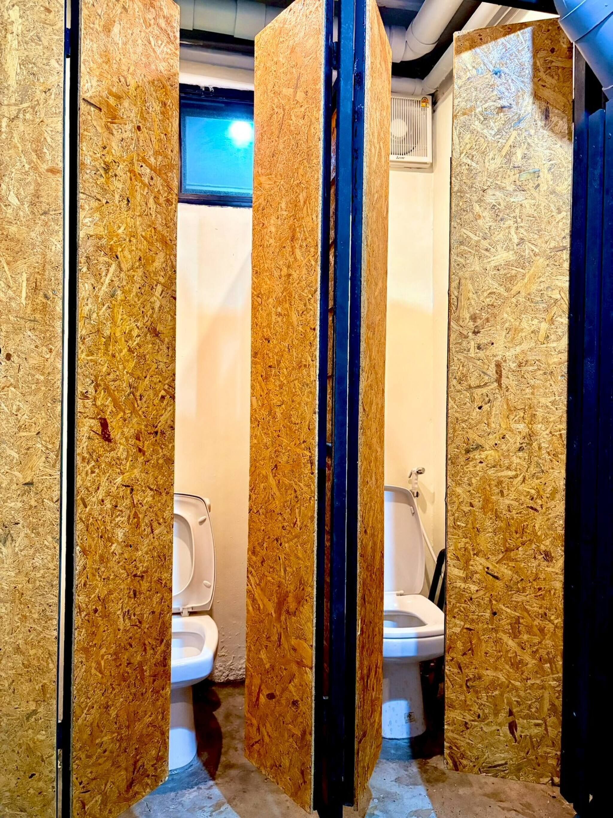 A restroom with two toilets separated by a partition.