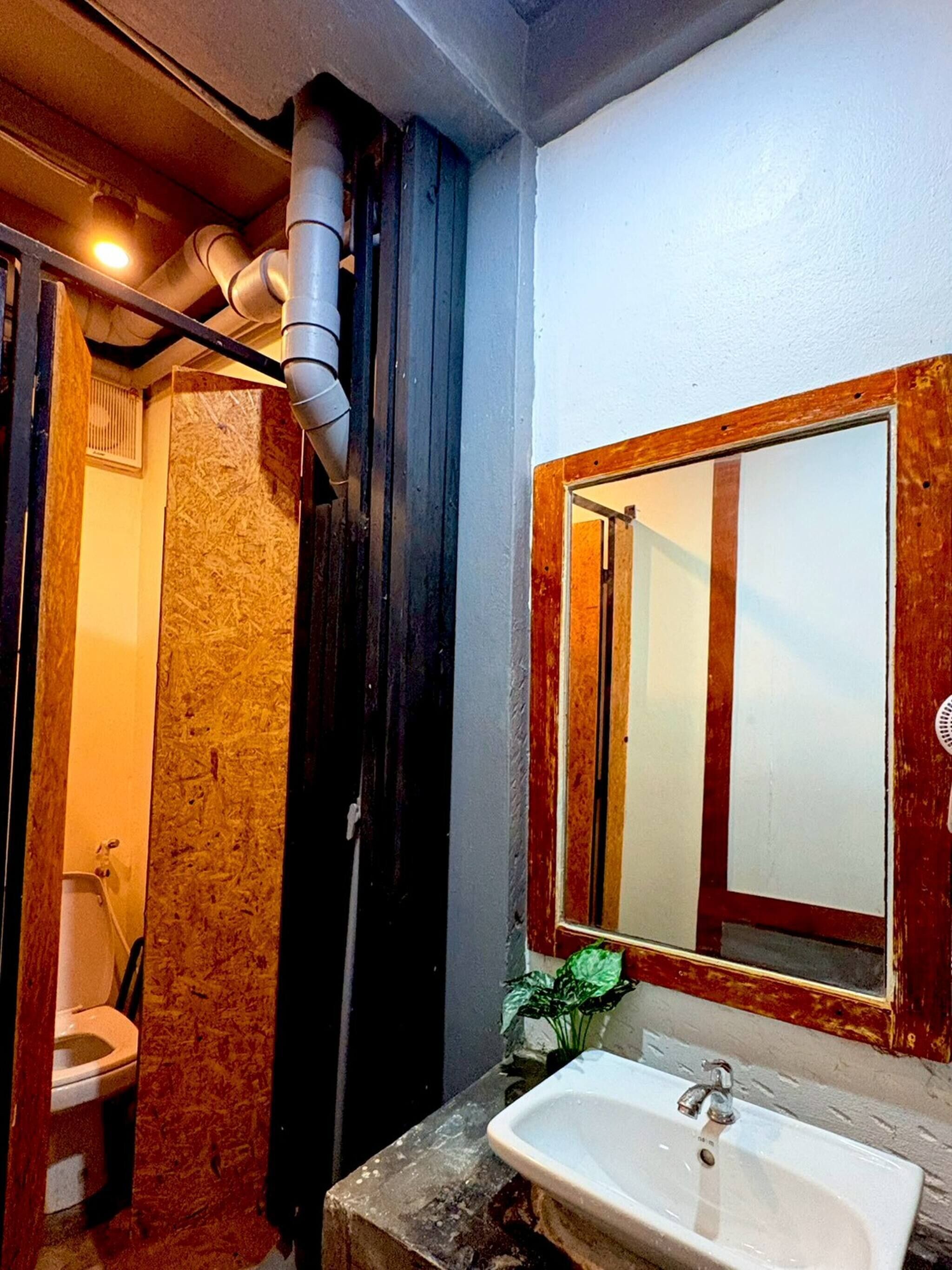 A bathroom with a toilet, sink, and mirror.