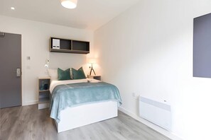 Ein modernes Schlafzimmer mit einem Bett, Nachttischen, einem Wandregal und einer Heizung.