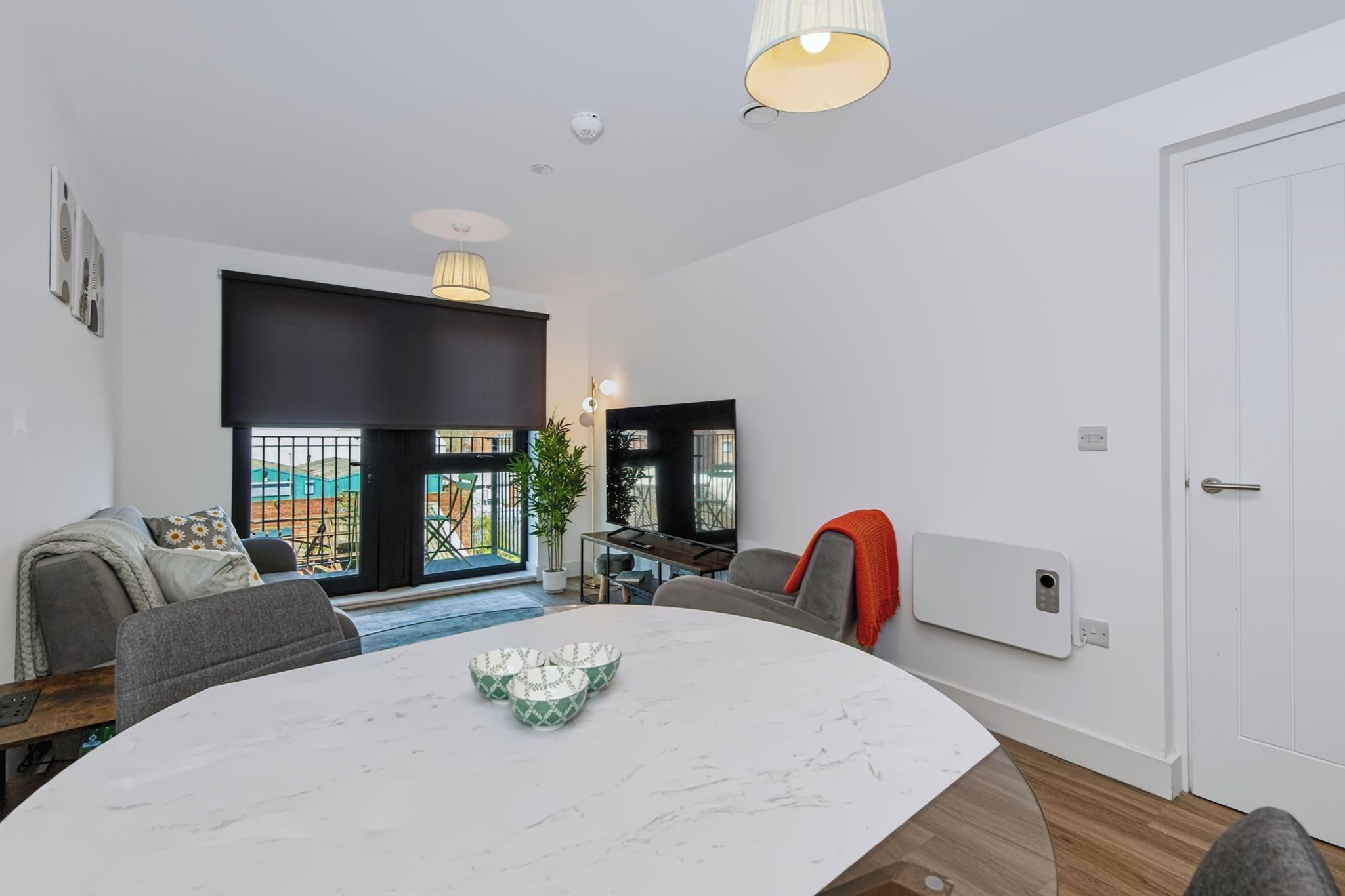 Un salón moderno con una mesa de comedor, sofá y vistas al exterior.