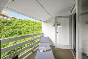 A balcony with a white railing, a grey mattress, and a door to the right. - Lovely holiday apartment in the heart of Søndervig close to the North Sea (Ringkøbing)