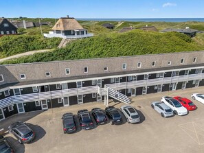 Ein Gebäude mit Parkplatz und mehreren Autos.