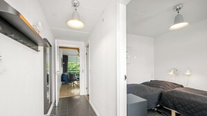 A modern bedroom with a bed, bedside lamps, and a view of an outdoor area. - Lovely holiday apartment in the heart of Søndervig close to the North Sea (Ringkøbing)