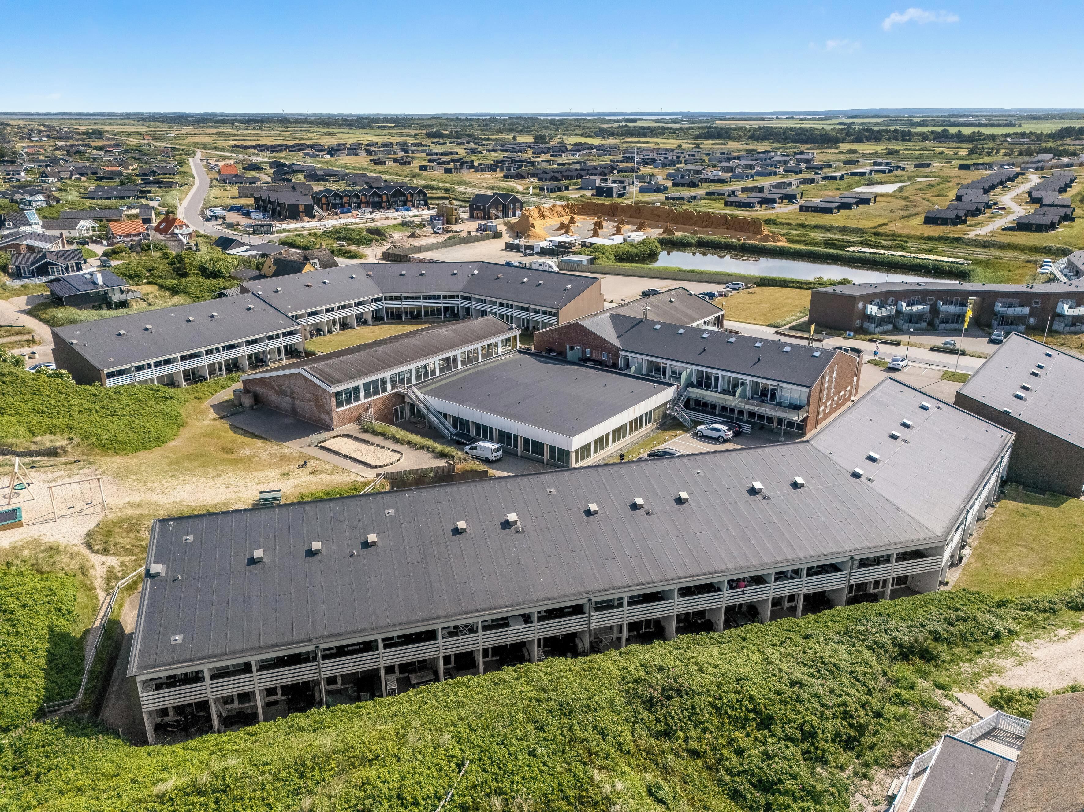 A large building with multiple sections, including a covered parking area and a central courtyard.