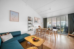 Un soggiorno moderno con un divano, un tavolino da caffè e un'area pranzo.