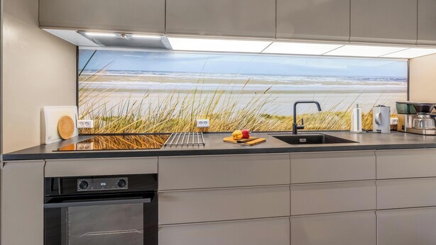 A kitchen with a large window, a sink, a coffee maker, and a microwave. - Bright and newly renovated holiday apartment close to the North Sea and. (Ringkøbing)