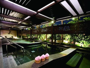 Un área de spa con hidromasaje, asientos y vistas a la vegetación.