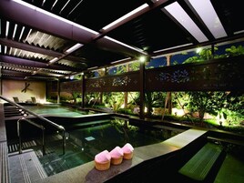 Un área de spa con hidromasaje, asientos y vistas a la vegetación.