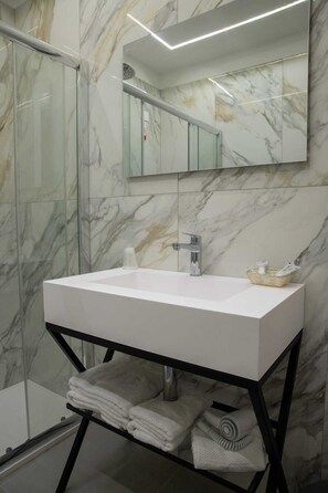 A bathroom with a white sink, a mirror, and marble walls. - Fortuna degli Dei (Tropea)