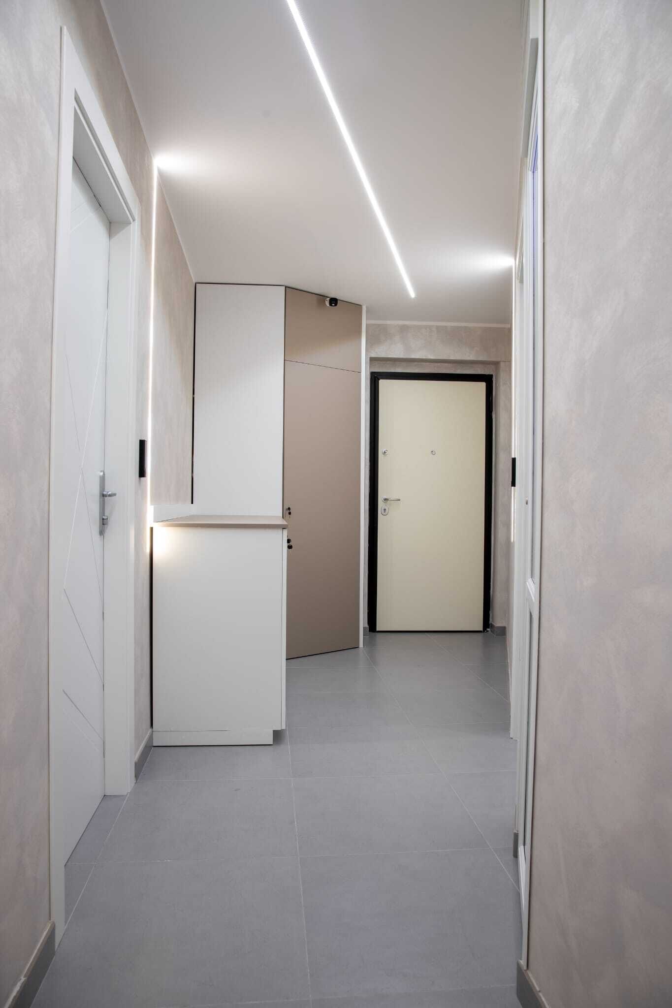 A hallway with a door, a cabinet, and a light fixture.