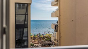 A view of a beachside balcony with a clear view of the sea and beach umbrellas. - Sea & Stay Studio | Durrës Waterfront by PikHost (Durrës)