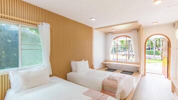 A hotel room with two beds, a window, a wooden wall, and a view of the outside.