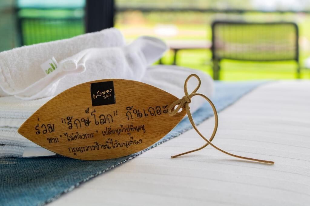 Una etiqueta de madera con texto, una toalla blanca y una tela azul sobre una superficie de madera.