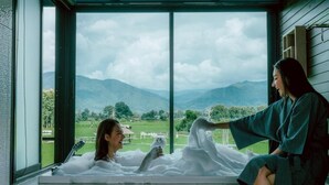 Una habitación con un amplio ventanal que ofrece vistas a montañas y un paisaje verde.