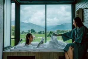 A room with a large window offering a view of mountains and a green landscape. - Sangthong Resort (Chiang Klang)