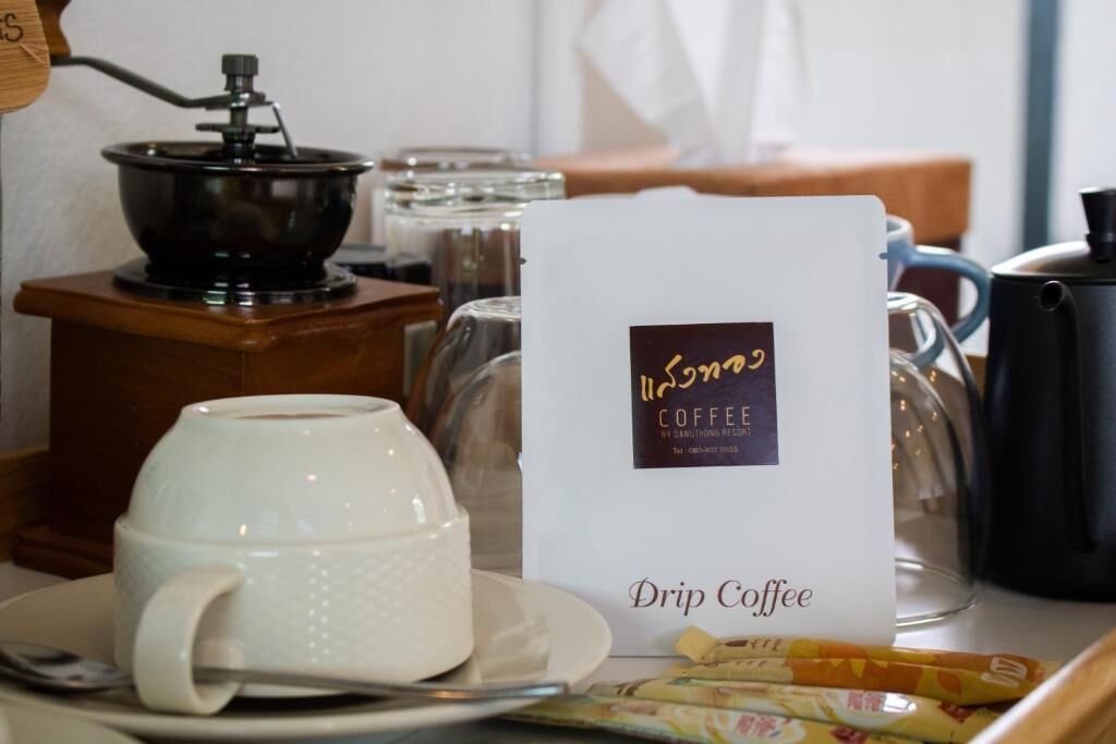 A drip coffee station with a coffee maker, a cup, and a menu card.