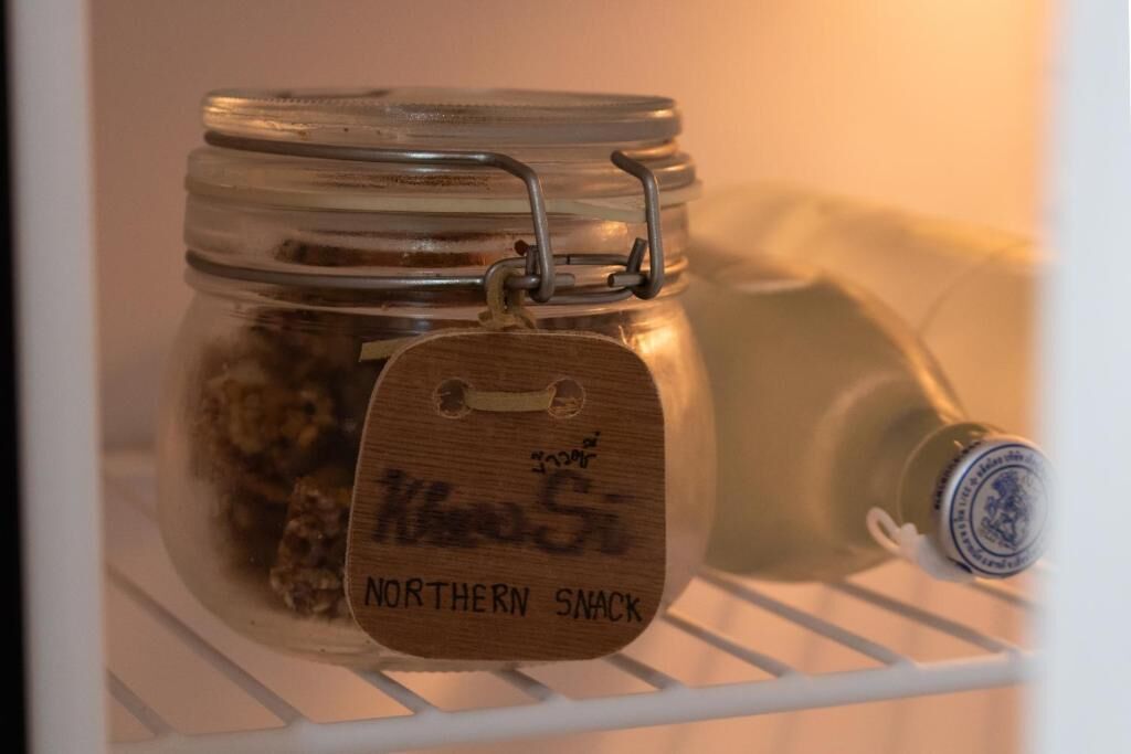 Un frasco de vidrio con un cierre metálico y una etiqueta de madera que dice 'Northern Snack' sobre un estante blanco.