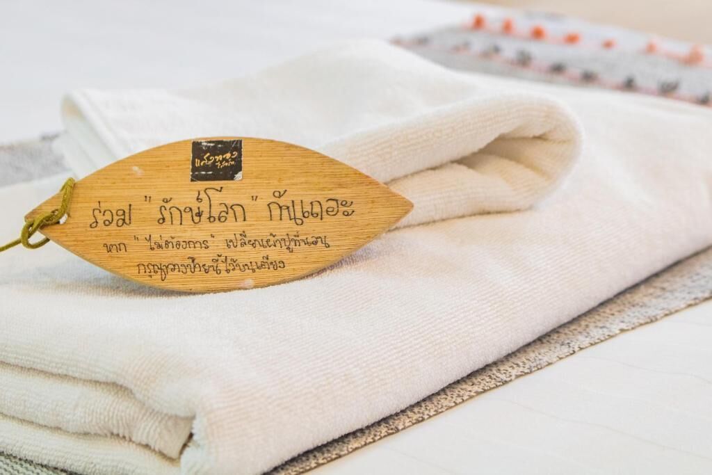 A folded white towel with a wooden tag.