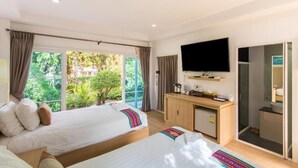 Una habitación de hotel con dos camas, televisión, escritorio y zona de ducha.