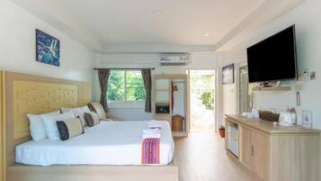 A hotel room with a bed, a TV, a desk, and a window.