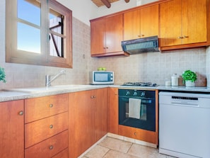 A kitchen with wooden cabinets, a microwave, stove, oven, and dishwasher. - Sea-view Retreat - Villas With Pools and Private Jacuzzi Cabin (Peristerona)