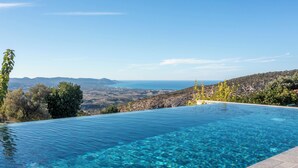 A clear blue infinity pool with a view of the sea and distant mountains. - Sea-view Retreat - Villas With Private Pools (Peristerona)