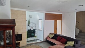 Una sala de estar con sofá, mesa de centro, chimenea y escalera.