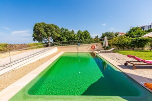 A rectangular swimming pool with clear water, surrounded by a paved deck, a lifebuoy, and a lounge chair. - Tavira Sweet - Convento das Bernardas (Tavira)